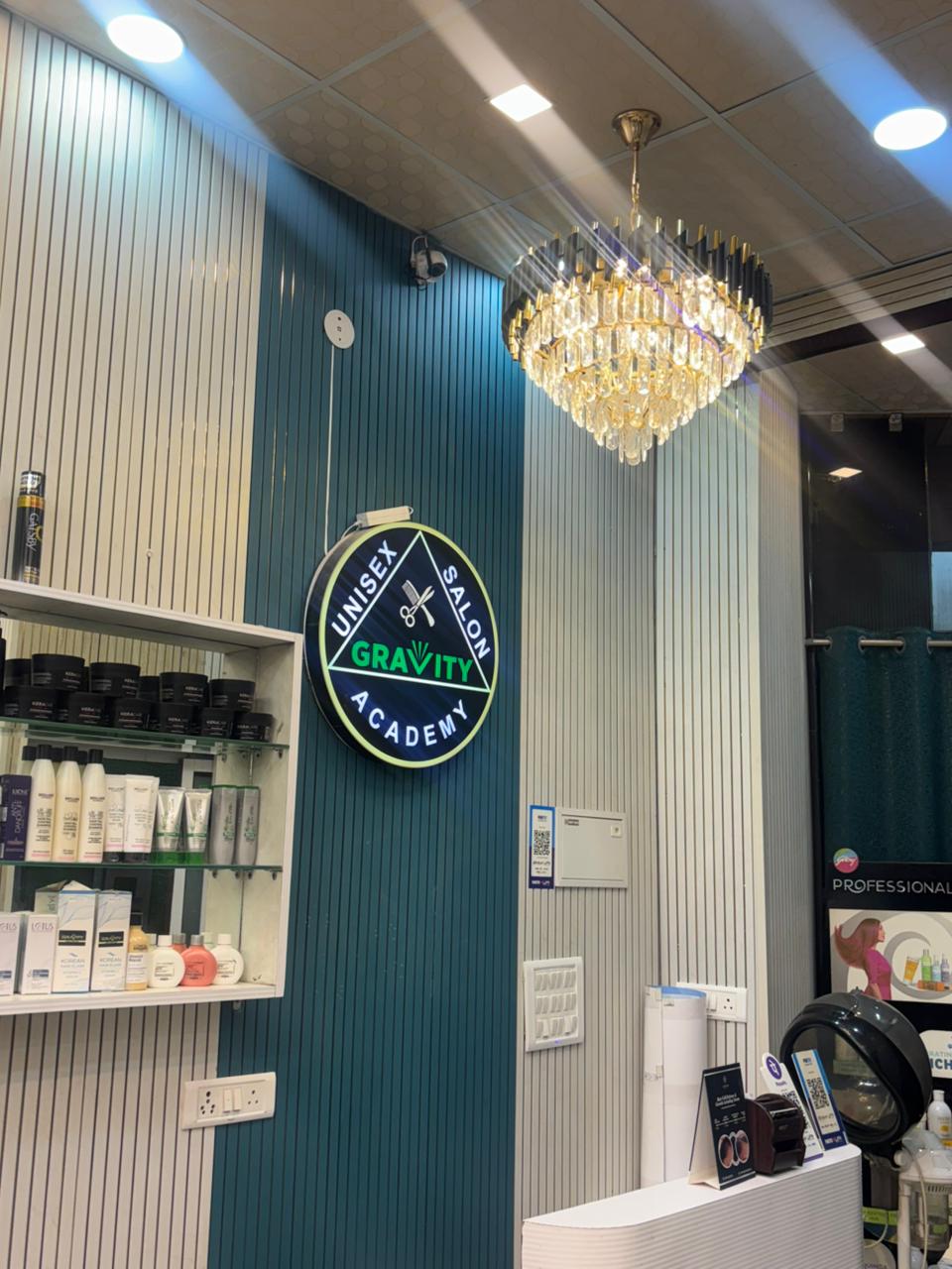 Gravity Unisex Salon & Academy brand wall with chandelier and product shelves